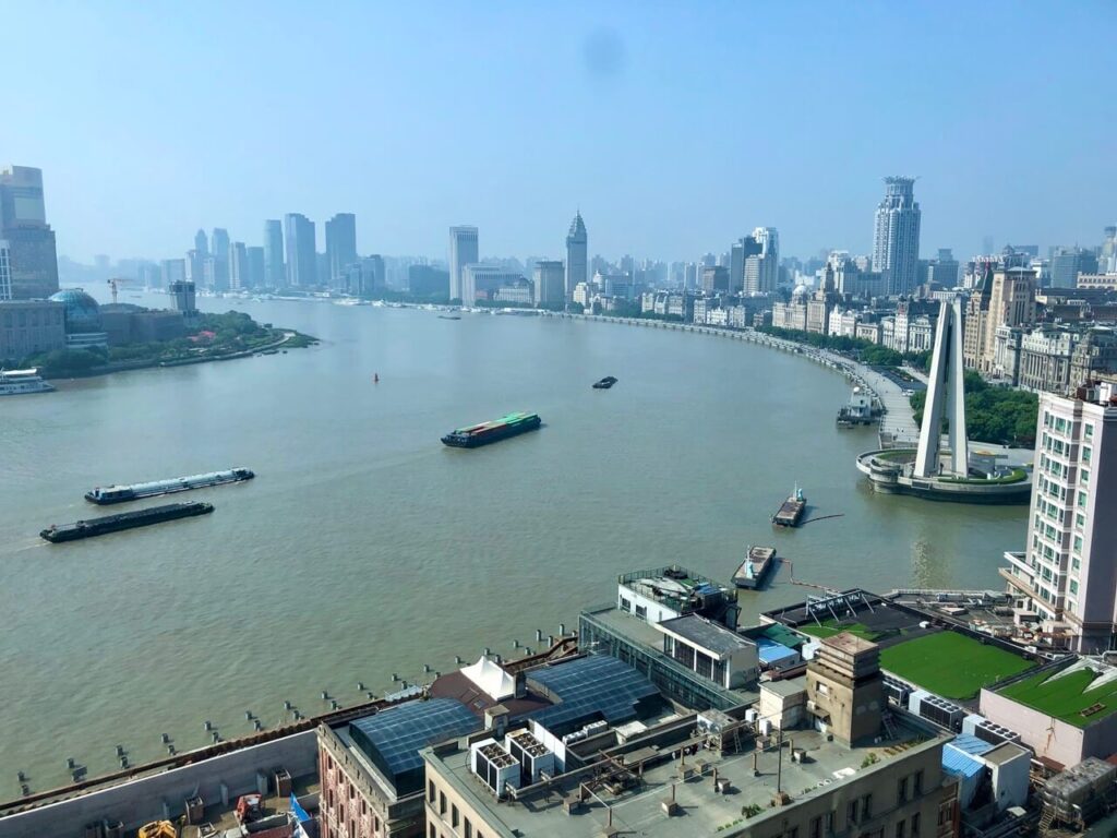 View of a river in Shanghai with boats and skyscrapers around